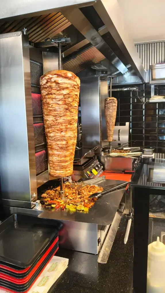 Tezgâhın arkasında dönen tavuk döner şişi